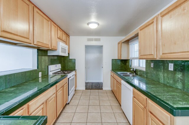 5535 N Millbrook Ave, Fresno, CA 93710 - kitchen featuring white appliances, light brown cabinetry, baseboards, a sink, and light tile patterned floors