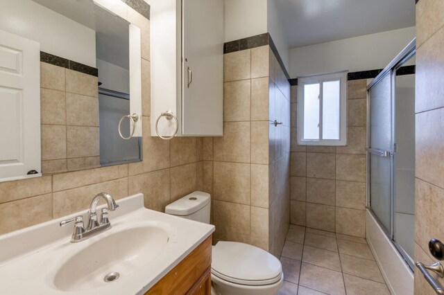 5535 N Millbrook Ave, Fresno, CA 93710 - full bathroom with tile walls, toilet, vanity, shower / bath combination with glass door, and tasteful backsplash