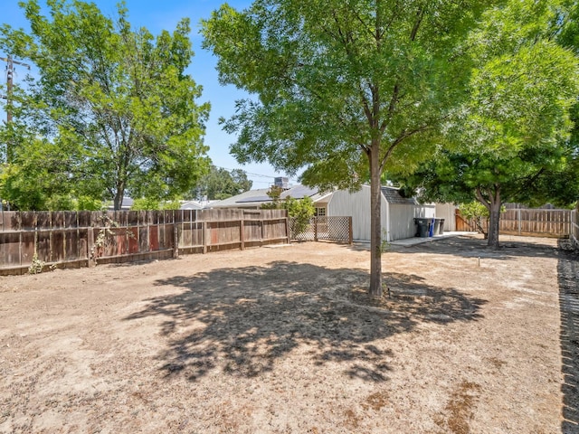fenced backyard with a storage shed and an outbuilding