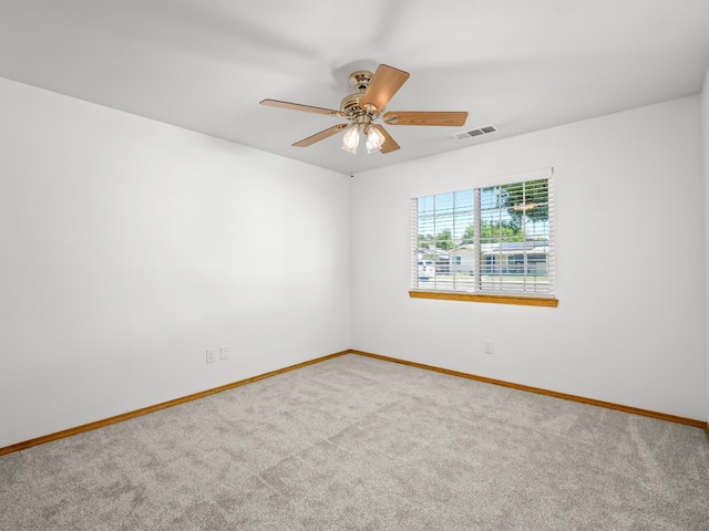 carpeted empty room featuring baseboards and ceiling fan
