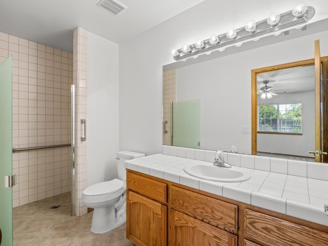 full bath with tile patterned flooring, a shower stall, a ceiling fan, toilet, and vanity