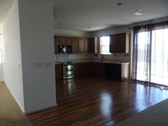 309 Pine Ct, Chowchilla, CA 93610 - kitchen with electric range, black microwave, light countertops, baseboards, and dark wood-style floors