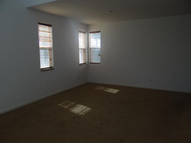 unfurnished room featuring carpet floors and baseboards