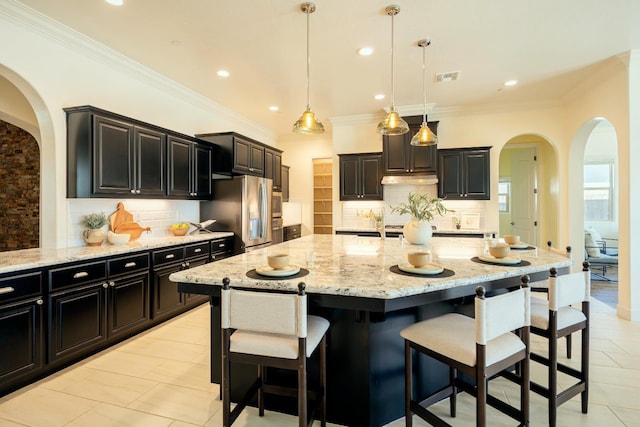 3636 Elberta Cir, Dinuba, CA 93618 - kitchen featuring arched walkways, stainless steel fridge, tasteful backsplash, light stone countertops, and recessed lighting