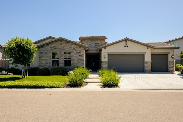 3636 Elberta Cir, Dinuba, CA 93618 - view of front of home featuring a garage, a front yard, driveway, stucco siding, and stone siding