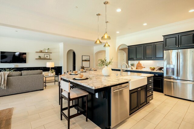 3636 Elberta Cir, Dinuba, CA 93618 - kitchen featuring appliances with stainless steel finishes, arched walkways, ornamental molding, a sink, and backsplash