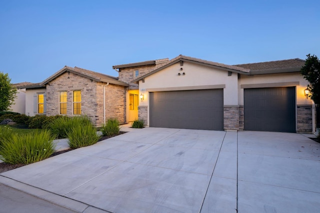 3636 Elberta Cir, Dinuba, CA 93618 - view of front facade with stone siding, an attached garage, driveway, and stucco siding