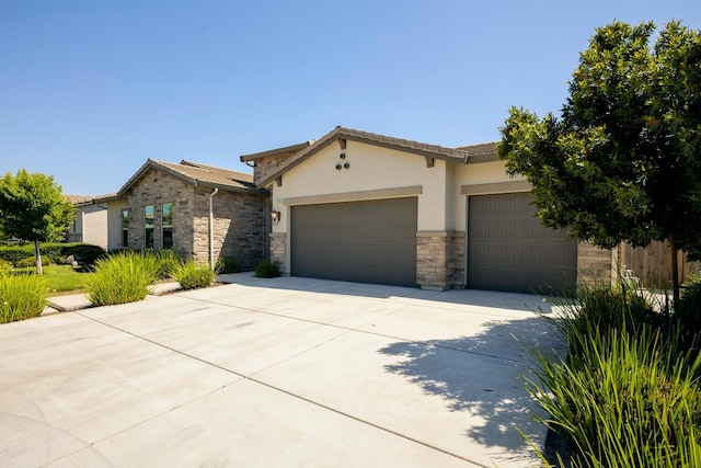 3636 Elberta Cir, Dinuba, CA 93618 - view of front of home with driveway, a garage, stucco siding, and stone siding