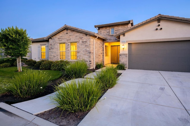 3636 Elberta Cir, Dinuba, CA 93618 - view of front of property featuring stone siding, an attached garage, driveway, and stucco siding