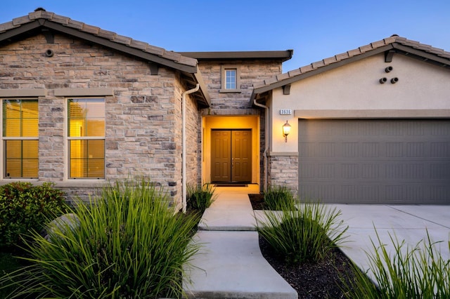 3636 Elberta Cir, Dinuba, CA 93618 - view of front of home with stone siding, a garage, concrete driveway, and stucco siding