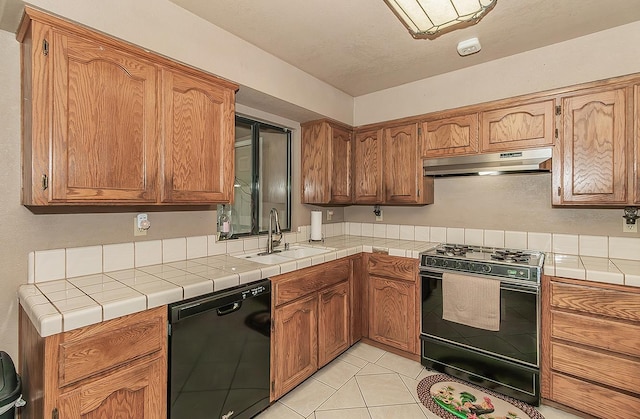 3732 W Garland Ave, Fresno, CA 93722 - kitchen featuring black appliances, under cabinet range hood, a sink, light tile patterned floors, and brown cabinetry