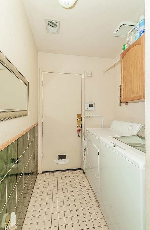 3732 W Garland Ave, Fresno, CA 93722 - laundry room with cabinet space, washer and clothes dryer, and light tile patterned flooring