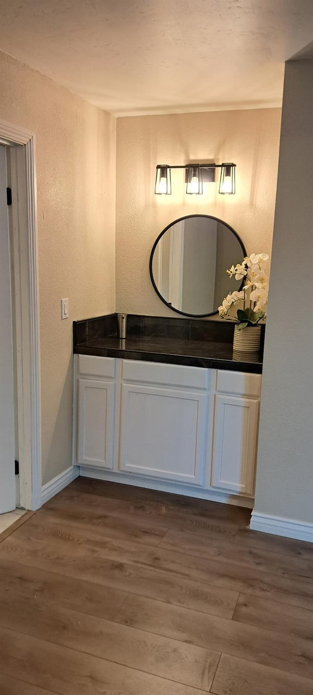 1690 W Wall Ln, Porterville, CA 93257 - bathroom featuring wood finished floors, a textured wall, baseboards, and vanity