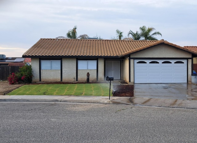 1690 W Wall Ln, Porterville, CA 93257 - view of front facade with an attached garage, concrete driveway, a tile roof, stucco siding, and a front yard