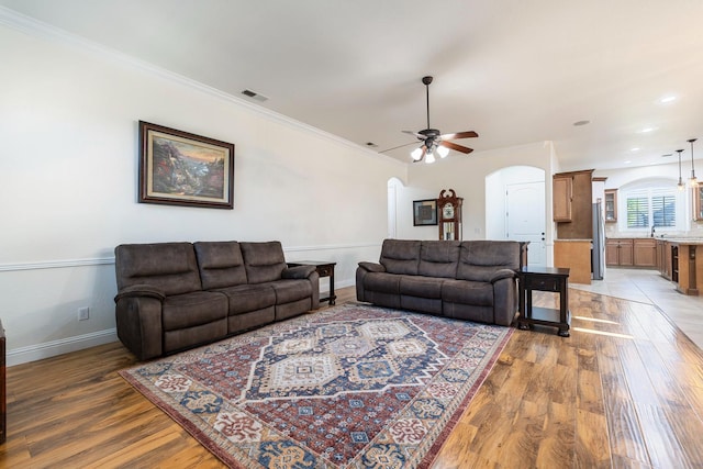 520 W Warwick, Clovis, CA 93619 - living room with arched walkways, a ceiling fan, light wood-type flooring, baseboards, and crown molding