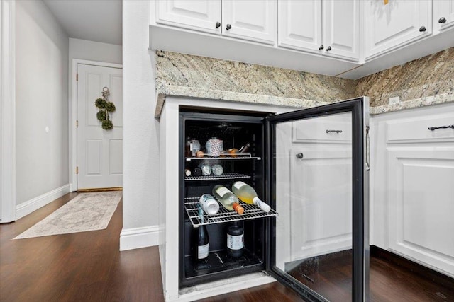 1117 E Royal Dornoch Ave, Fresno, CA 93730 - detailed view of white cabinets, dark wood-style flooring, baseboards, and light stone counters