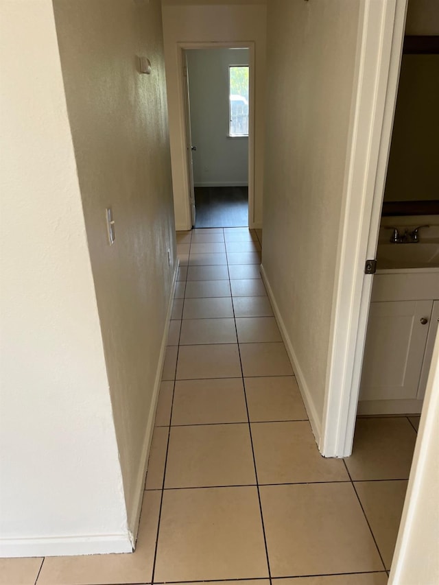 2645 W Robinson Ave, Fresno, CA 93705 - hallway featuring light tile patterned floors, baseboards, and a sink