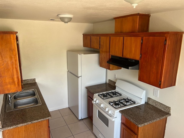 2645 W Robinson Ave, Fresno, CA 93705 - kitchen featuring under cabinet range hood, white appliances, a sink, brown cabinetry, and light tile patterned floors