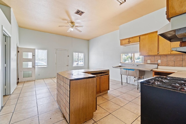900 Sonora St, Madera, CA 93638 - kitchen featuring range hood, ceiling fan, light tile patterned floors, tasteful backsplash, and tile counters