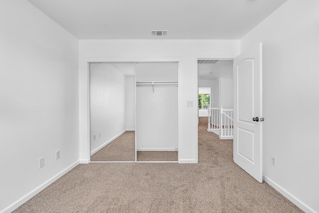 unfurnished bedroom with carpet flooring, baseboards, and a closet