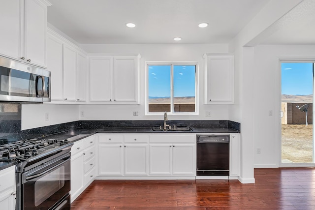kitchen featuring black appliances, a sink, dark wood-style floors, white cabinets, and recessed lighting