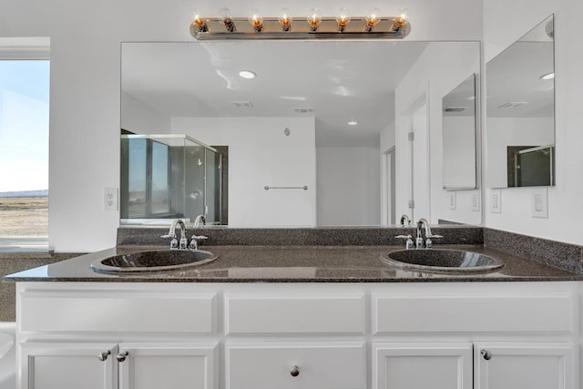 full bath with a stall shower, plenty of natural light, and double vanity