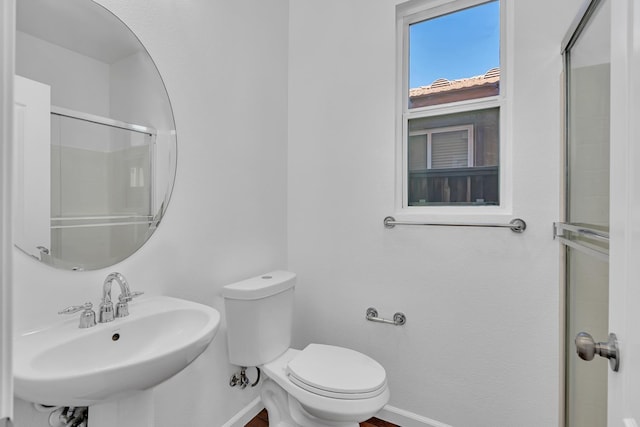 full bath featuring a sink, baseboards, toilet, and an enclosed shower