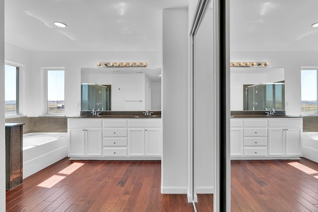 full bathroom with a garden tub, a shower stall, vanity, and hardwood / wood-style floors