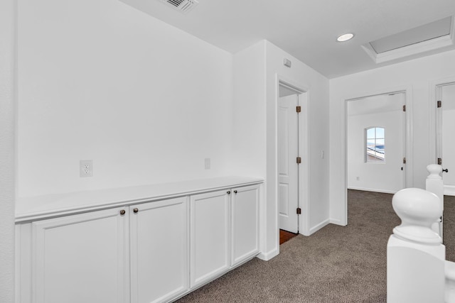 hallway with dark colored carpet, baseboards, and recessed lighting