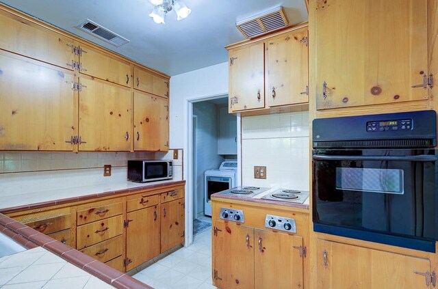 3948 E Fedora Ave, Fresno, CA 93726 - kitchen featuring oven, washer / clothes dryer, stainless steel microwave, and backsplash