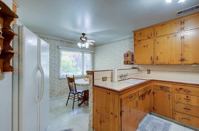 3948 E Fedora Ave, Fresno, CA 93726 - kitchen featuring wallpapered walls, freestanding refrigerator, tile countertops, a peninsula, and light flooring