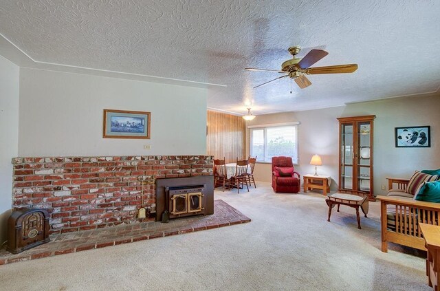 3948 E Fedora Ave, Fresno, CA 93726 - living room with a wood stove, carpet floors, ceiling fan, and a textured ceiling