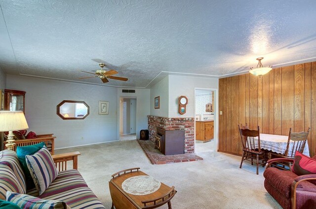 3948 E Fedora Ave, Fresno, CA 93726 - carpeted living area with ceiling fan, a textured ceiling, wooden walls, and a fireplace