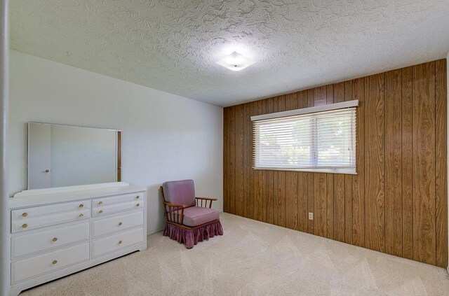 3948 E Fedora Ave, Fresno, CA 93726 - living area with wooden walls, carpet flooring, and a textured ceiling