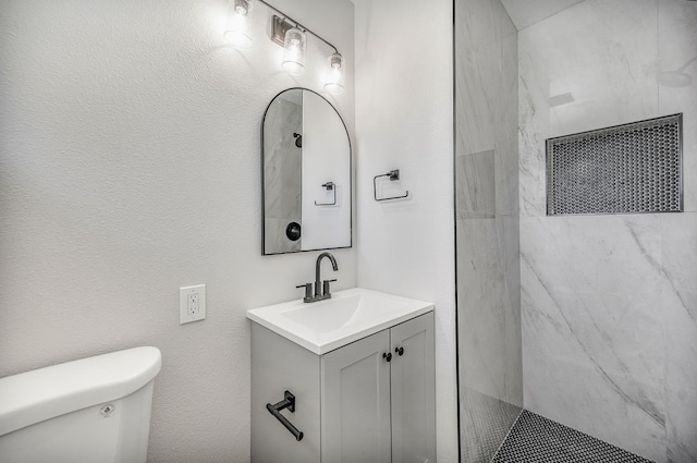 bathroom with toilet, walk in shower, and vanity