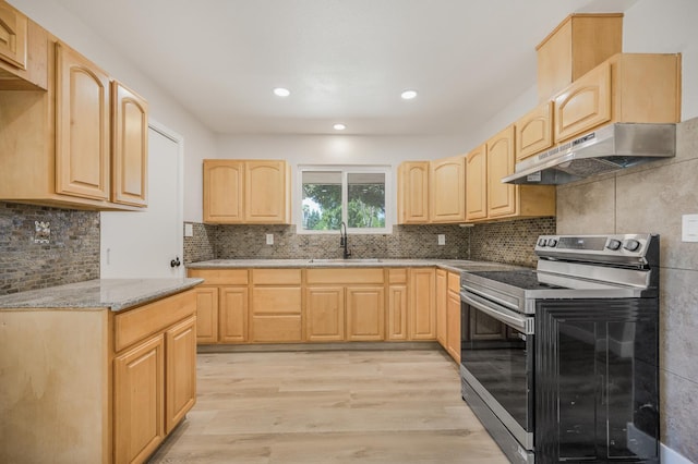 kitchen with stainless steel electric stove, light brown cabinetry, under cabinet range hood, a sink, and light wood-style flooring