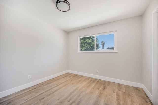 empty room with baseboards and light wood-type flooring