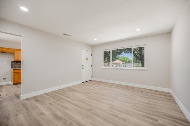 spare room with light wood-style flooring, recessed lighting, and baseboards