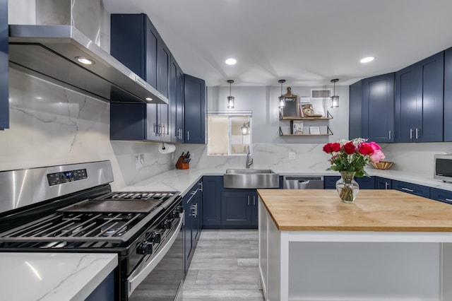 2983 E Northdale Ave, Fresno, CA 93726 - kitchen featuring appliances with stainless steel finishes, a sink, wall chimney exhaust hood, wood counters, and blue cabinetry
