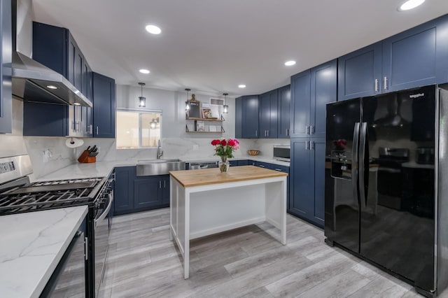 2983 E Northdale Ave, Fresno, CA 93726 - kitchen with appliances with stainless steel finishes, wooden counters, blue cabinetry, wall chimney range hood, and recessed lighting