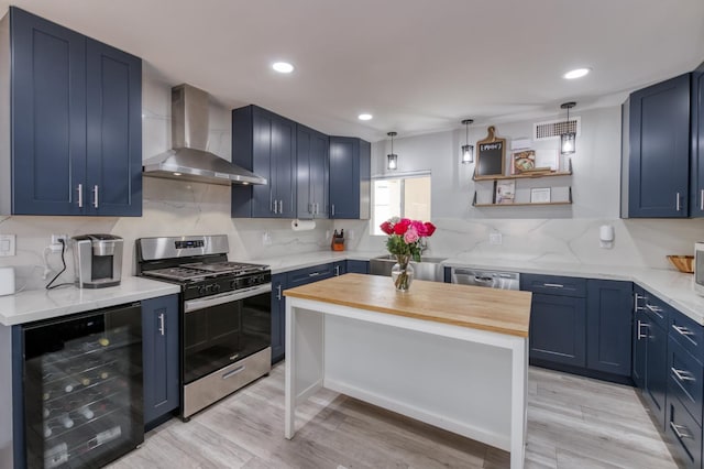 2983 E Northdale Ave, Fresno, CA 93726 - kitchen with wall chimney range hood, wine cooler, appliances with stainless steel finishes, blue cabinetry, and light wood-style flooring