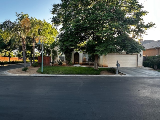 4769 N Emerald Peak Dr, Clovis, CA 93619 - obstructed view of property featuring asphalt driveway, a garage, fence, and stucco siding
