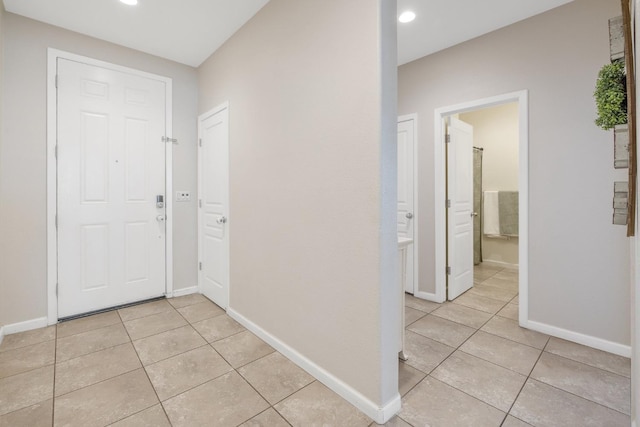 hallway with light tile patterned flooring, baseboards, and recessed lighting