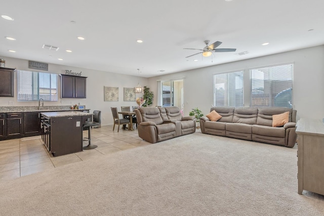 living area with recessed lighting, light tile patterned floors, a ceiling fan, and light carpet