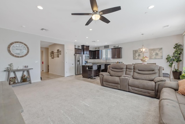 living area with a ceiling fan, light carpet, recessed lighting, and baseboards