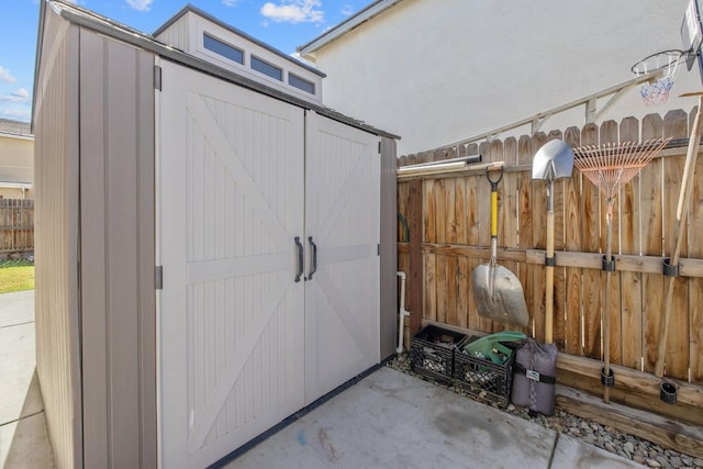 view of shed featuring fence