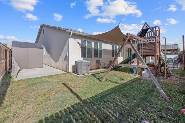 rear view of house featuring a playground, cooling unit, stucco siding, and a patio area