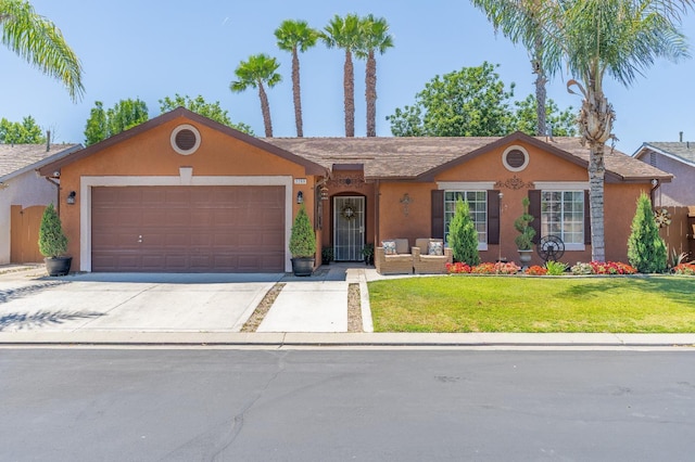 5266 E Harvest Ln, Fresno, CA 93725 - ranch-style home featuring stucco siding, an attached garage, driveway, a front lawn, and an outdoor hangout area