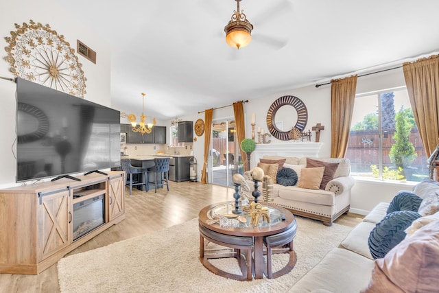 5266 E Harvest Ln, Fresno, CA 93725 - living room with a chandelier, light wood-style floors, and a ceiling fan