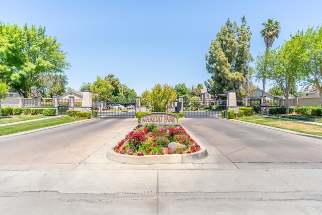 5266 E Harvest Ln, Fresno, CA 93725 - view of concrete road with a gate, curbs, and a gated entry